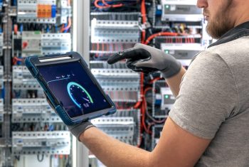 Electrician analyzing data. Tablet in use. Digital switchboard control.