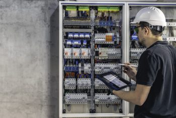 Man, an electrical technician working in a switchboard with fuses.